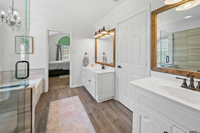 bathroom with ornamental molding, hardwood / wood-style floors, an enclosed shower, and vanity