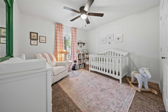 bedroom featuring a crib, carpet flooring, and ceiling fan