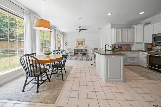 kitchen with tasteful backsplash, stainless steel appliances, white cabinetry, decorative light fixtures, and sink