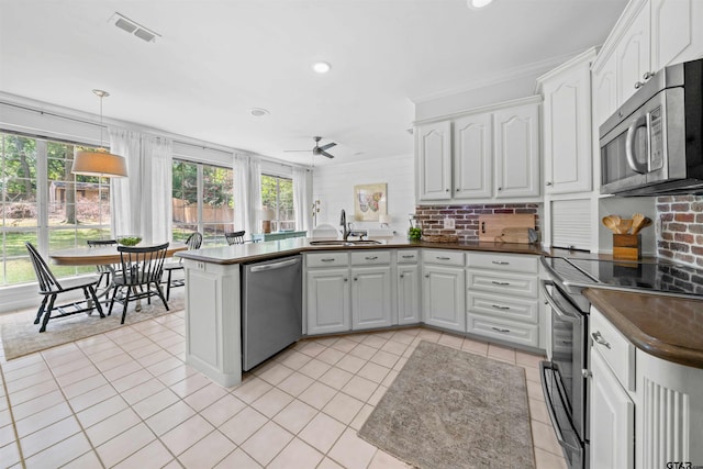 kitchen with stainless steel appliances, sink, white cabinets, kitchen peninsula, and ceiling fan