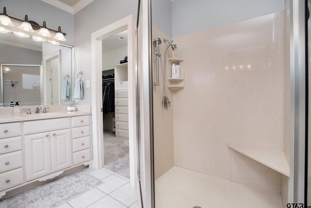 11208 Marsh Wren Cir, Flint, TX 75762 - bathroom with ornamental molding, a stall shower, vanity, a walk in closet, and tile patterned flooring