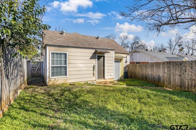 back of property featuring a fenced backyard and a yard