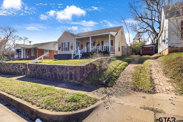 view of front of home featuring covered porch and fence