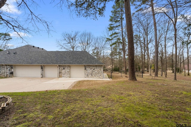 view of side of home featuring a garage and a yard