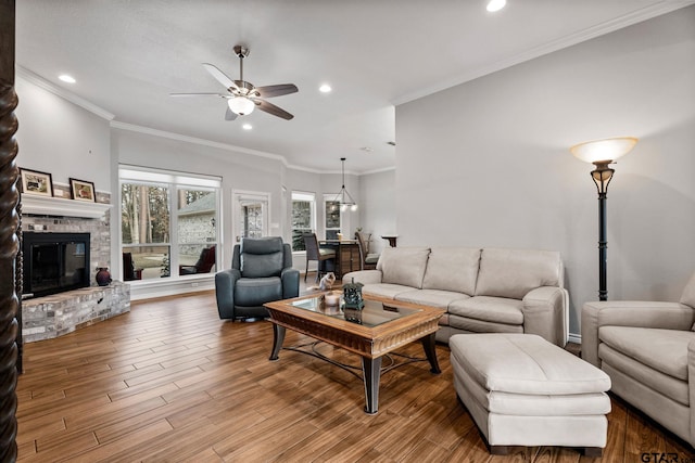 living room featuring wood-type flooring, ornamental molding, and ceiling fan