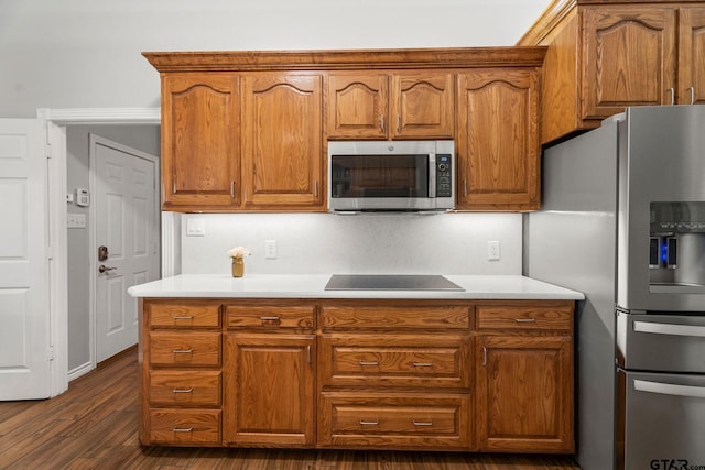 kitchen with stainless steel appliances and dark hardwood / wood-style flooring