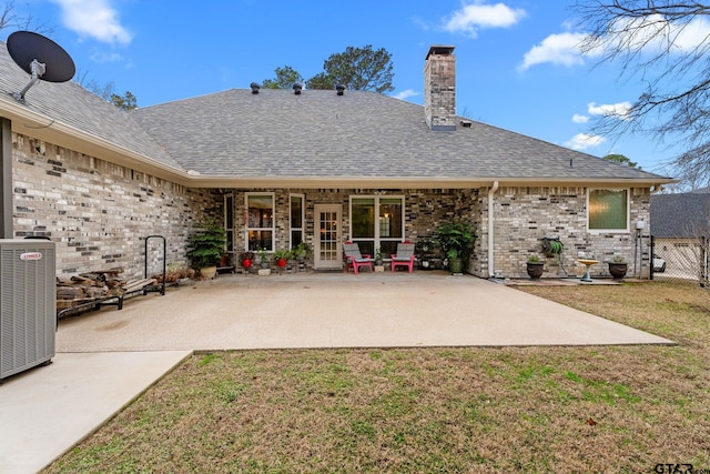 back of house featuring central AC unit, a yard, and a patio