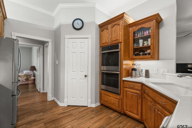 kitchen with stainless steel appliances, crown molding, sink, and dark hardwood / wood-style flooring