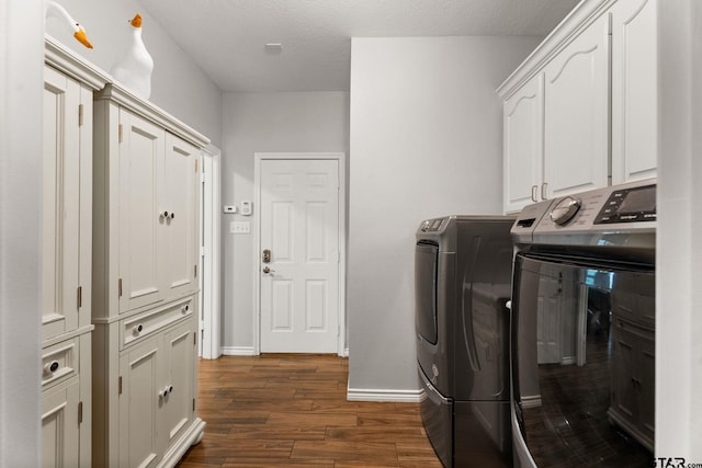 clothes washing area with cabinets, dark hardwood / wood-style flooring, washer and dryer, and a textured ceiling