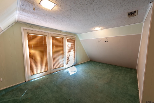 bonus room with carpet floors, a textured ceiling, and vaulted ceiling