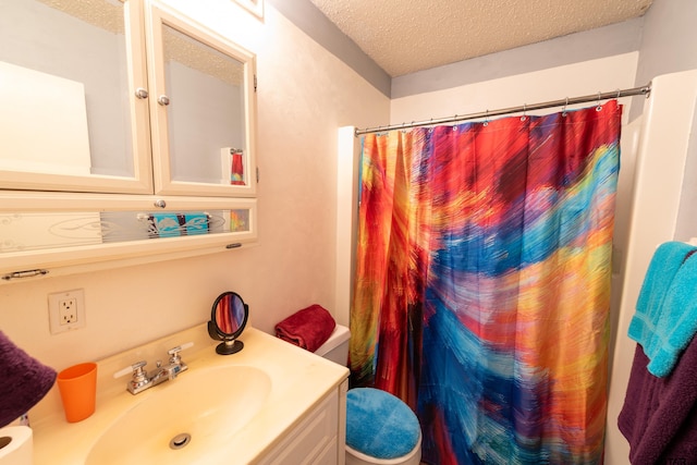 bathroom with curtained shower, vanity, a textured ceiling, and toilet