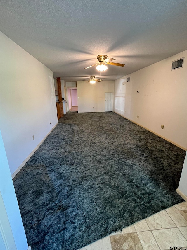 carpeted spare room featuring a textured ceiling and ceiling fan