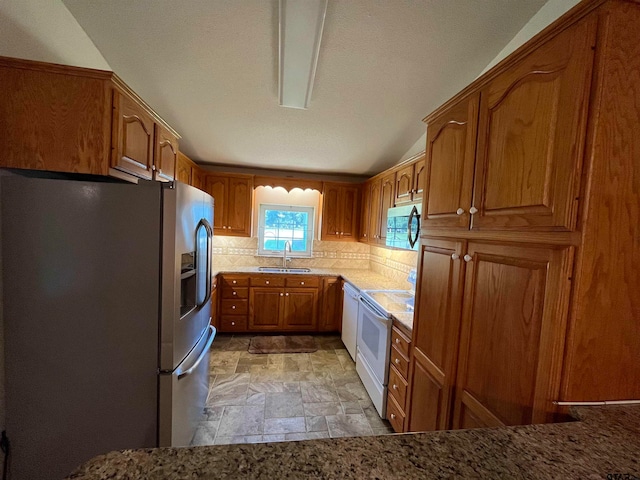 kitchen with backsplash, stainless steel fridge, sink, and white electric range