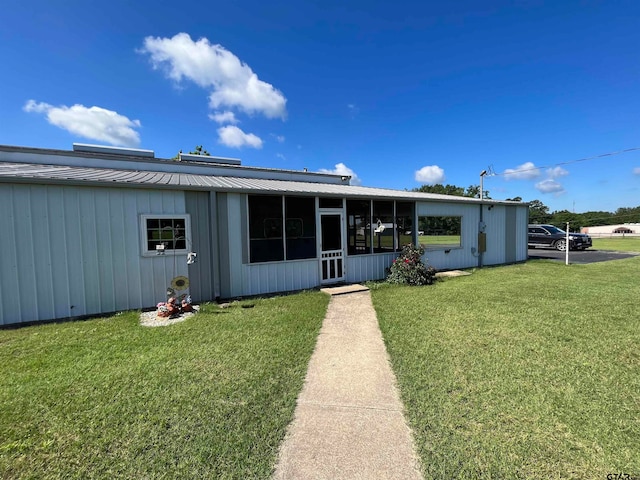 back of house featuring a sunroom and a yard