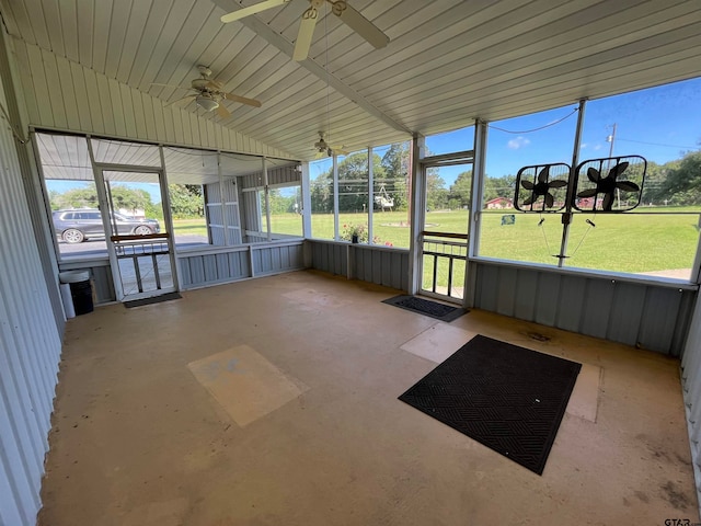 unfurnished sunroom featuring ceiling fan, a healthy amount of sunlight, and lofted ceiling