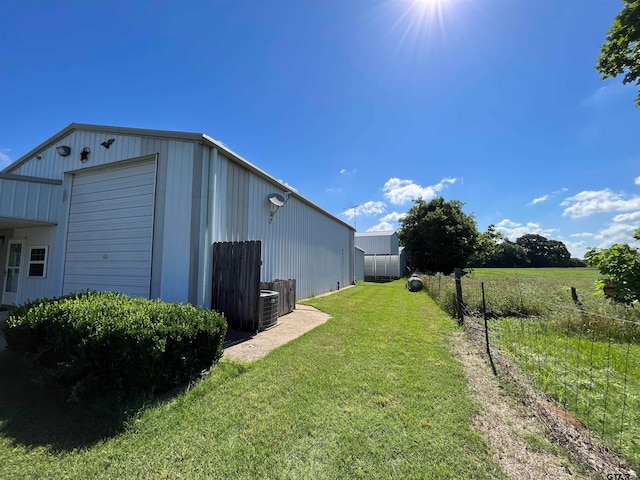 view of yard with an outbuilding, a garage, and cooling unit