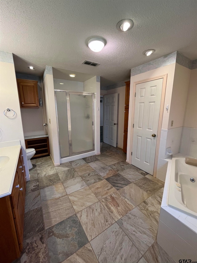 full bathroom with vanity, a textured ceiling, toilet, and shower with separate bathtub