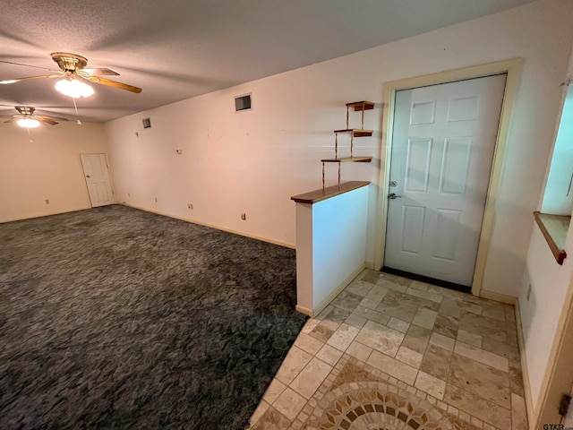 foyer entrance featuring a textured ceiling and ceiling fan