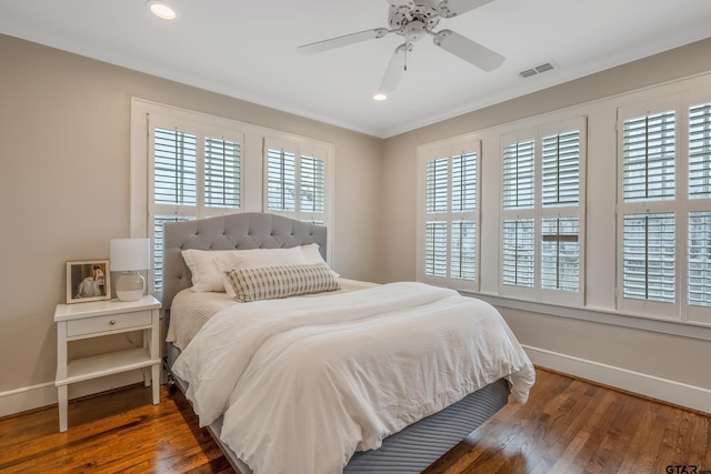 bedroom featuring crown molding, dark hardwood / wood-style floors, and ceiling fan