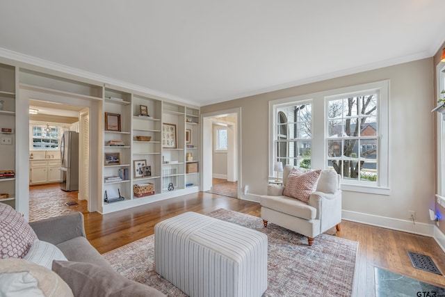 living area featuring crown molding and wood-type flooring