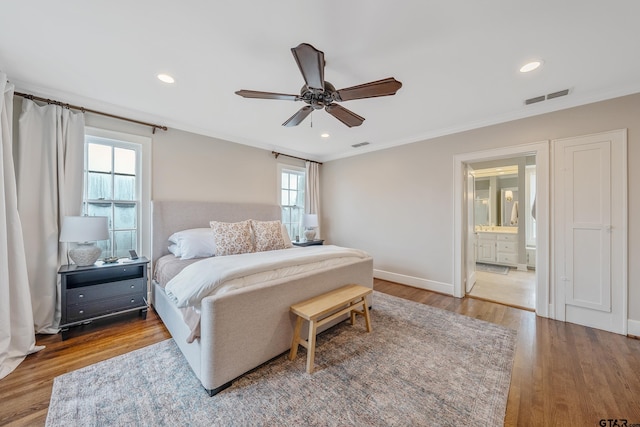 bedroom with connected bathroom, hardwood / wood-style floors, crown molding, and ceiling fan