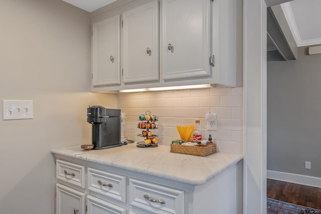 kitchen featuring white cabinetry, dark wood-type flooring, and backsplash