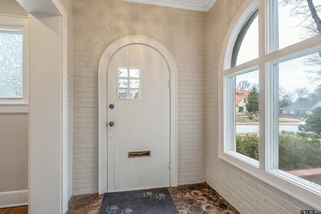 entrance foyer with brick wall and a wealth of natural light