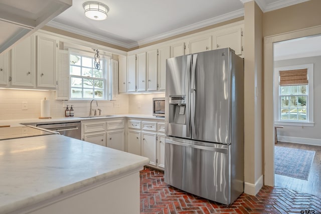 kitchen with sink, ornamental molding, appliances with stainless steel finishes, white cabinets, and backsplash