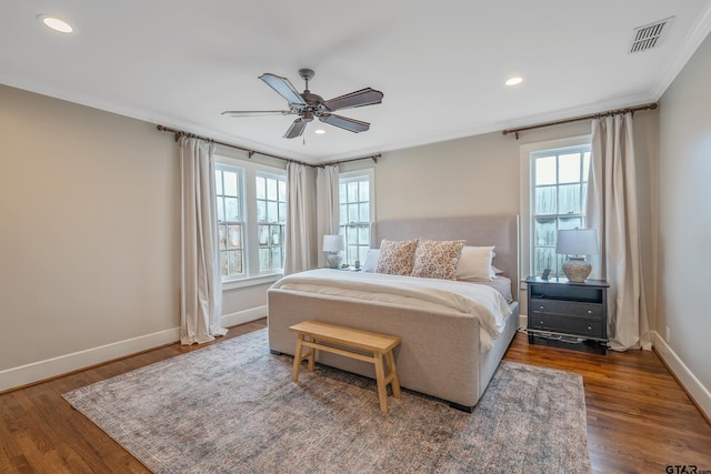 bedroom with multiple windows, dark hardwood / wood-style flooring, and ornamental molding