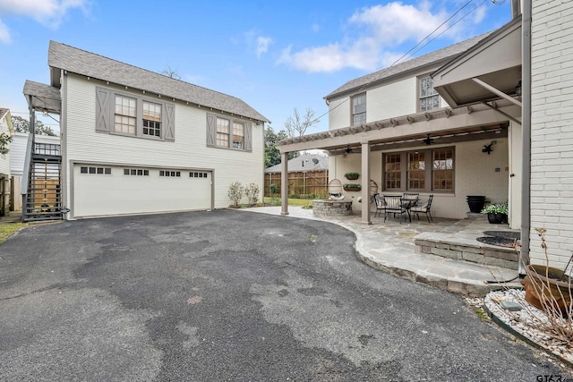 exterior space with a garage, ceiling fan, and a patio area