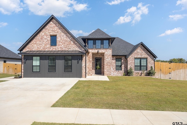 view of front facade featuring fence, a shingled roof, a front lawn, board and batten siding, and brick siding