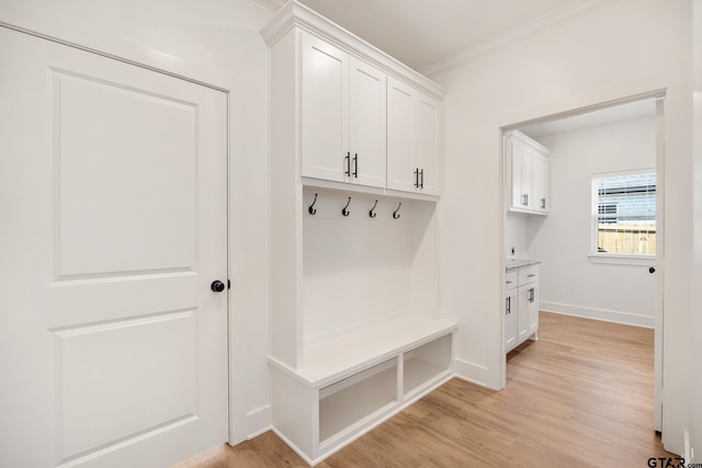 mudroom featuring light wood-type flooring, baseboards, and crown molding