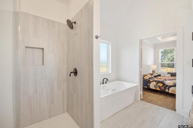 ensuite bathroom featuring a freestanding tub, connected bathroom, and tiled shower