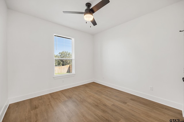 unfurnished room with ceiling fan, baseboards, and wood finished floors