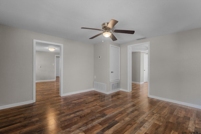 spare room featuring baseboards, visible vents, ceiling fan, and dark wood-style flooring