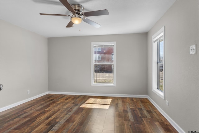 spare room with a healthy amount of sunlight, baseboards, dark wood finished floors, and a ceiling fan