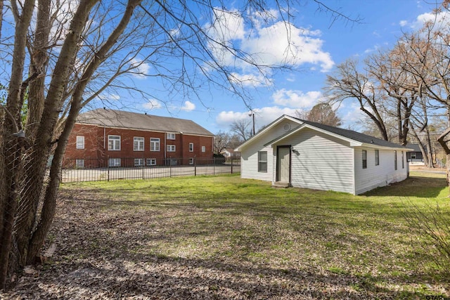 rear view of property with entry steps, a lawn, and fence