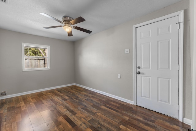 spare room with ceiling fan, baseboards, dark wood finished floors, and a textured ceiling