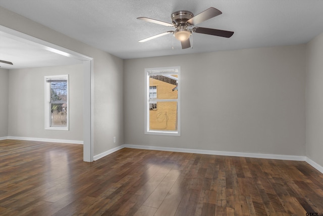 unfurnished room featuring ceiling fan, a textured ceiling, baseboards, and dark wood-type flooring