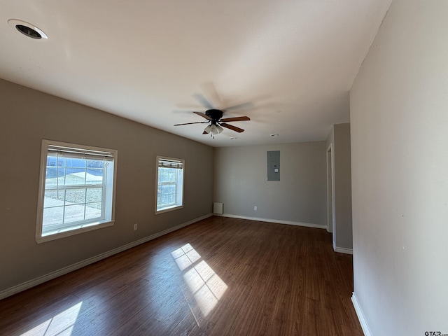 spare room with electric panel, baseboards, and dark wood finished floors