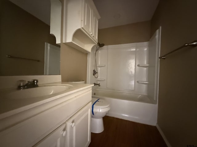 bathroom featuring toilet, tub / shower combination, wood finished floors, and vanity