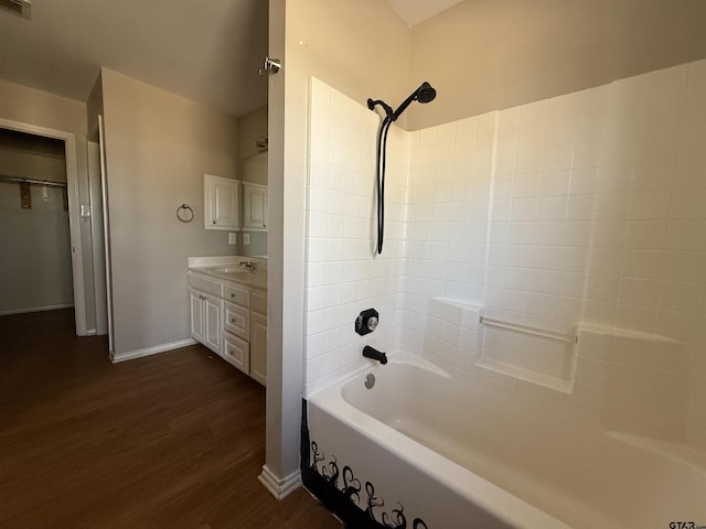 bathroom with shower / washtub combination, wood finished floors, vanity, and baseboards