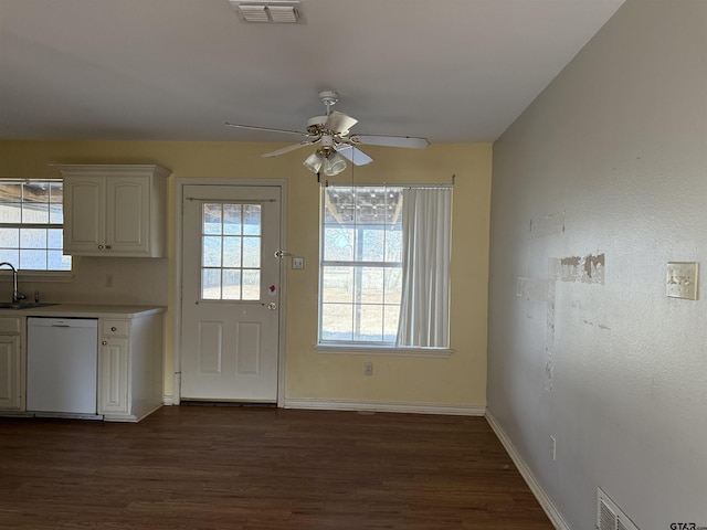 doorway featuring dark wood finished floors, visible vents, a sink, and baseboards