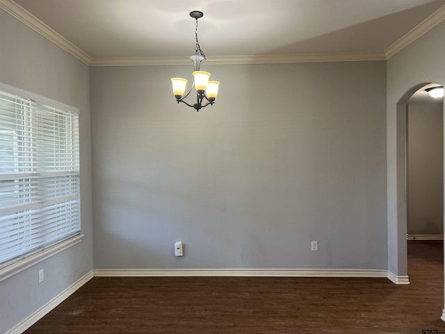 empty room featuring dark hardwood / wood-style flooring, crown molding, and an inviting chandelier