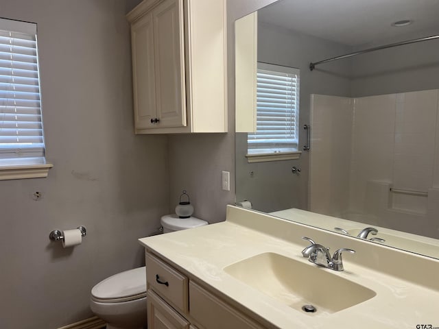 bathroom with a shower, vanity, and toilet