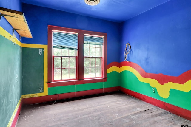 unfurnished room with baseboards and wood finished floors
