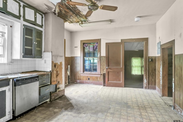 kitchen featuring dishwasher, wooden walls, and a wainscoted wall