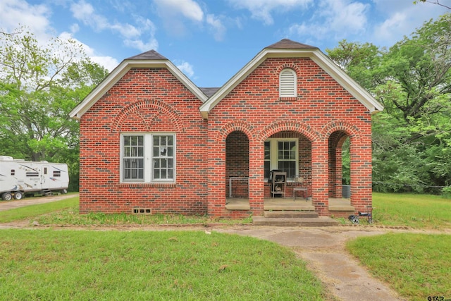 view of front of home with brick siding, a porch, and a front lawn