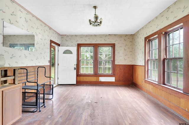 foyer entrance featuring wallpapered walls, hardwood / wood-style flooring, and a healthy amount of sunlight