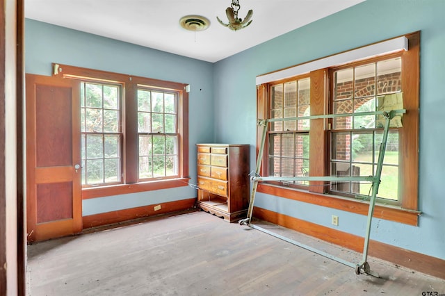 unfurnished room featuring baseboards, wood finished floors, and visible vents